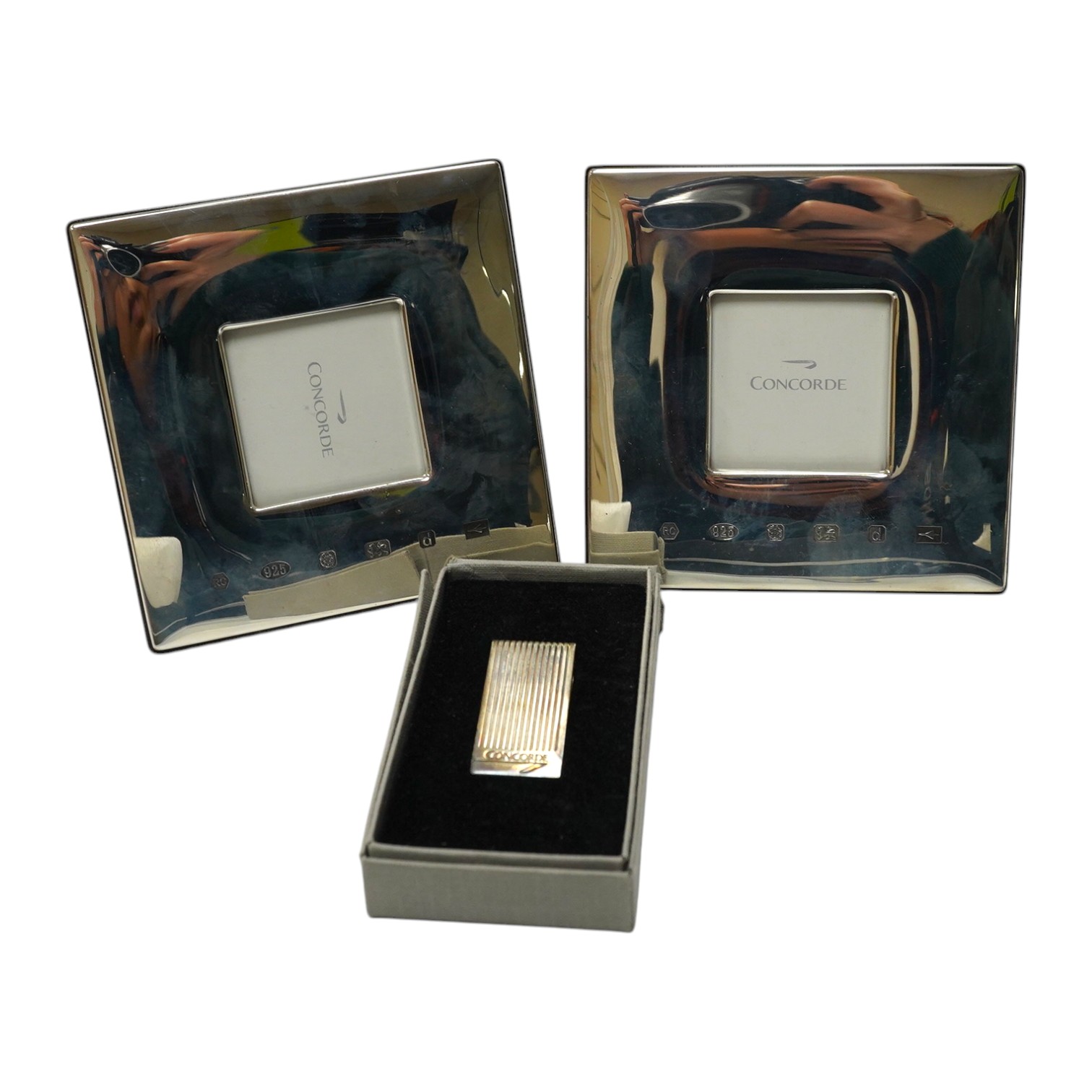 Two boxed modern silver mounted Concorde photograph frames, 12.1cm, Carr's of Sheffield, 1003, together with a silver Concorde money clip. Condition - good